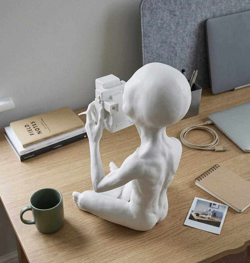 Alieno con Fotocamera Polaroid — Statuetta da Collezione in ResinaUn piccolo visitatore da un altro mondo che non si perde un solo momento.L'Alieno con Fotocamera Polaroid porta ironia e mistero intergalattico sulla tua scrivania: TarafloTarafloAlieno con Fotocamera