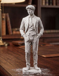Statua uomo elegante effetto gesso bianco in abito formale su scrivania in legno con libreria sullo sfondo
