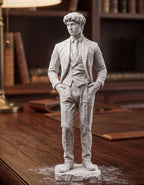 Statua uomo elegante effetto gesso bianco in abito formale su scrivania in legno con libreria sullo sfondo