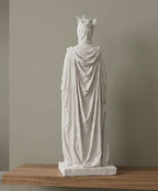 Vista posteriore della statua bianca con cappuccio drappeggiato e corona su base rettangolare