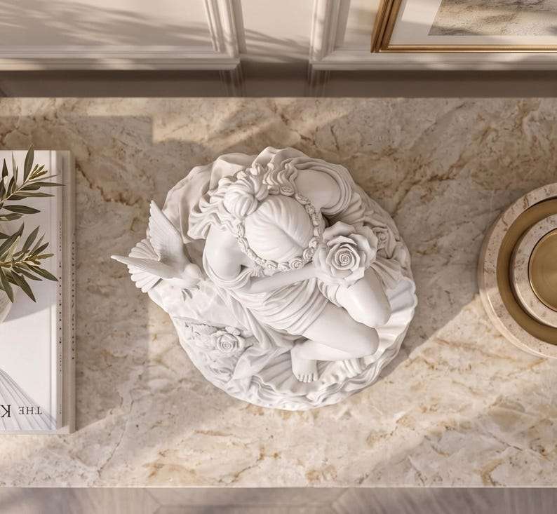 Vista dall'alto della statua bianca di Venere seduta su una roccia con rosa e uccellino