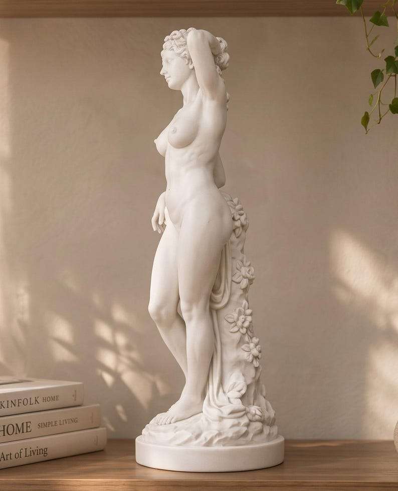 Vista laterale della statua di Venere su base rotonda con fiori scolpiti sulla colonna di supporto