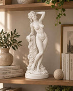 Inquadratura completa della statua classica di Venere su mensola accanto a libri impilati