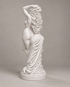 Vista posteriore della statua di Venere bianca con lunga chioma riccia e drappeggio sul corpo