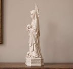 Vista laterale della statua bianca della figura sacra gotica su superficie in legno