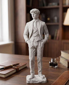Statua bianca di uomo in abito classico con cravatta e mani in tasca su scrivania in legno