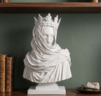Busto frontale di figura femminile velata con corona floreale su base rettangolare bianca