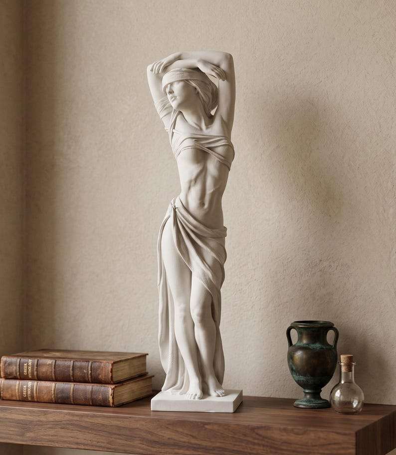 Statua femminile bianca effetto gesso con benda sugli occhi affiancata da libri e vaso metallico