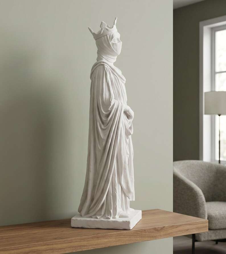 Vista laterale della statua bianca di regina velata con corona e drappeggio