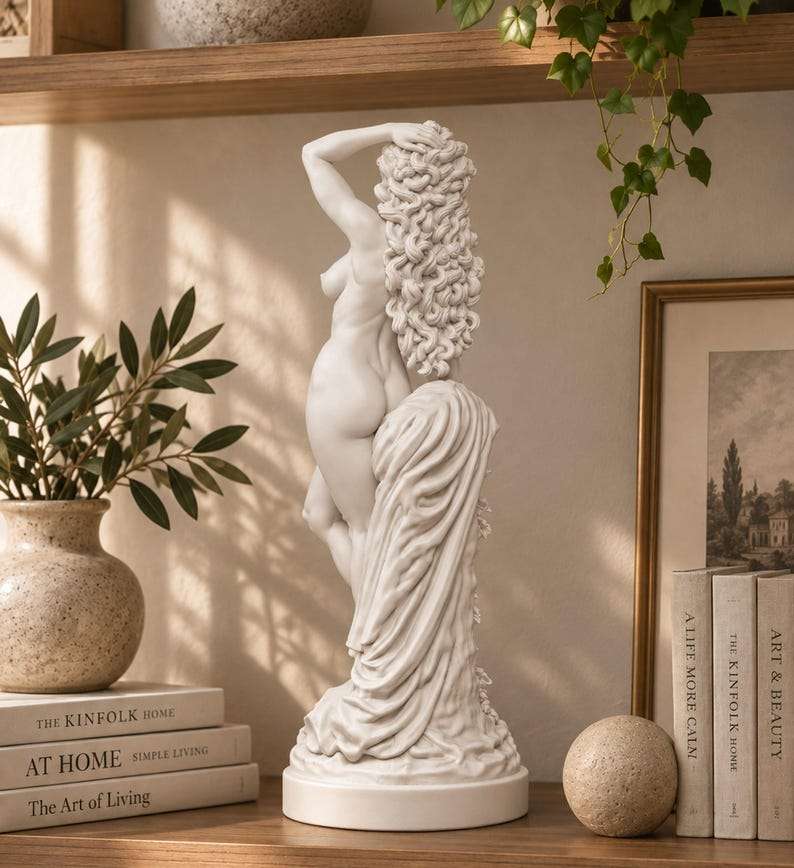 Vista posteriore della statua bianca di Venere con lunghi capelli ricci e drappeggio, su scaffale in legno