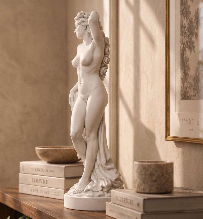 Vista di profilo della statua di Venere in piedi su base tonda davanti a una cornice