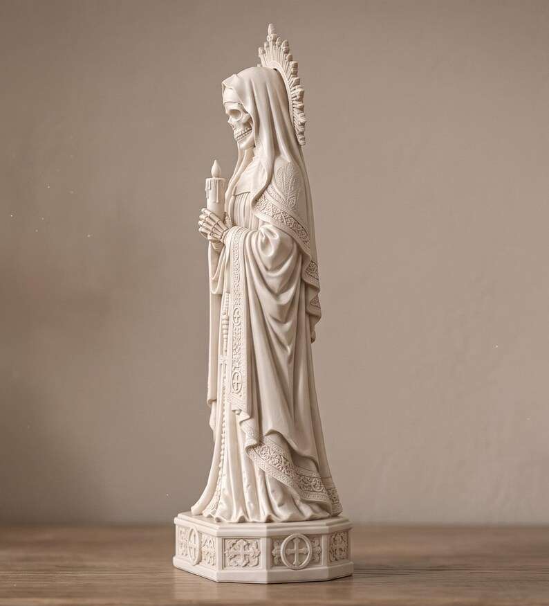 Vista laterale ravvicinata della statua Santa Muerte bianca con mantello e rosario